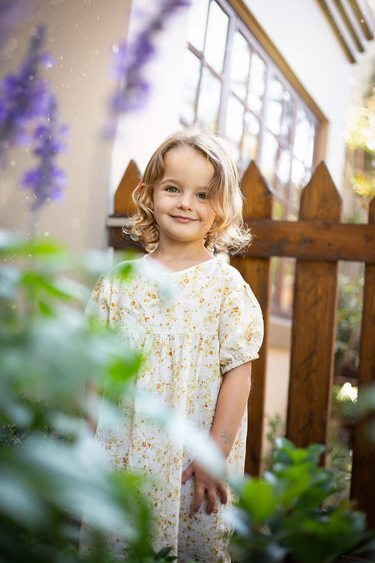 little girl by purpler flowers